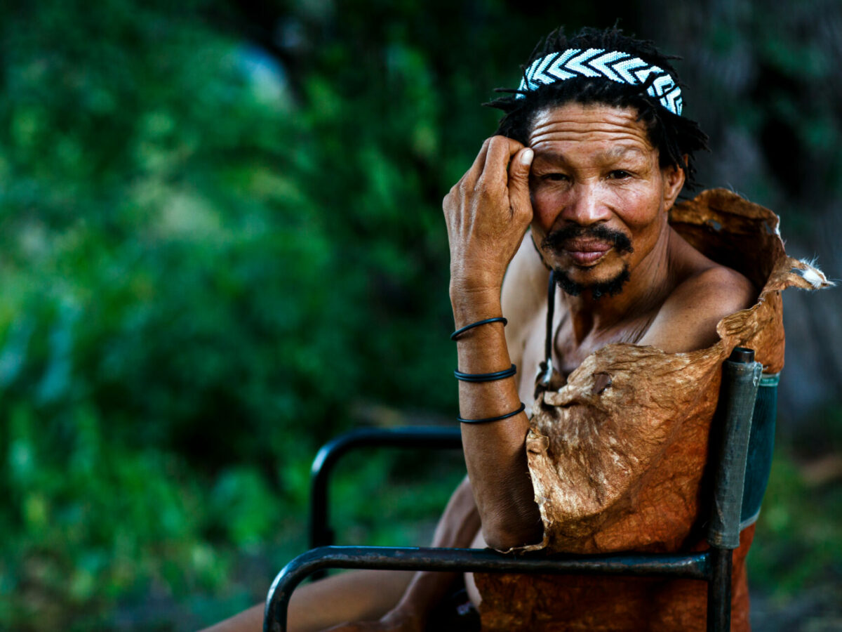 portrait of a male Xaixai Khoi San seated wearing traditional headress