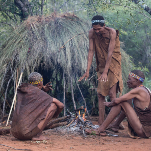 three Xaixai Khoi San grouped around a bush fire for warmth