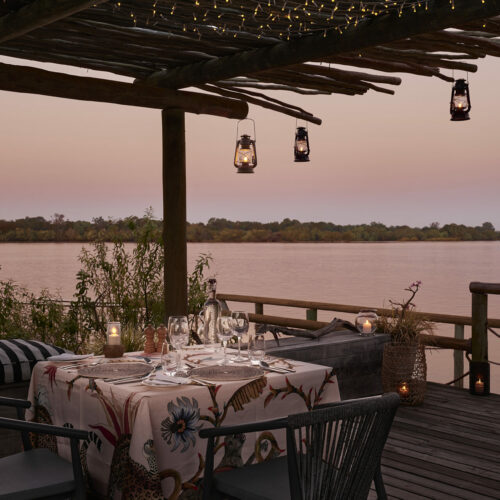 Evening dinner table on a deck at Victoria Falls River Lodge