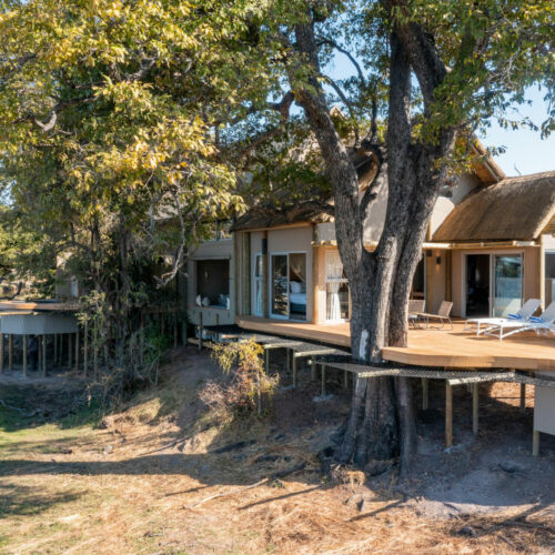 View of the exterior of a suite amidst trees at Victoria Falls River Lodge
